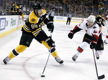 Boston Bruins' Kevan Miller (86) takes a shot as Ottawa Senators' Jean-Gabriel Pageau (44) defends during the second period of an NHL hockey game in Boston, Saturday, Jan. 3, 2015.