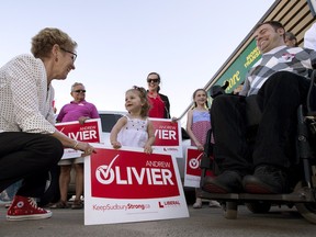 Ontario Liberal leader Kathleen Wynne greets two-year-old Ella Prosperi as she arrives at a campaign event for candidate Andrew Olivier (right) in Sudbury, Ontario on Tuesday May 27, 2014, 2014.
