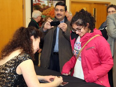 Kavita Srivastava, 18, gets her music CD signed by Angela Hewitt while her dad, Vineet, a board member with the Ottawa Chamber Music Society, captures the moment on camera following Hewitt's sold-out performance on Wednesday, January 14, 2015, at Domion-Chalmers United Church.