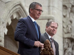 Newfoundland and Labrador Premier Paul Davis and Municipal and Intergovernmental Affairs Minister Keith Hutchings (right) are recognized following Question Period in the House of Commons Friday December 12, 2014 in Ottawa.