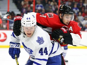 Kyle Turris of the Ottawa Senators battles against Morgan Rielly of theToronto Maple Leafs during third period NHL action.
