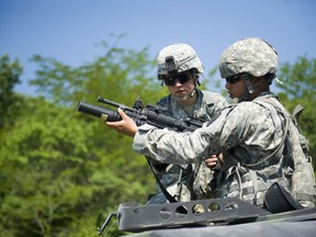 Military Police Sgt. Samantha Houston assists Spc. Joshua Tarazona, 81st Troop Command, in firing an M203 grenade launcher at Camp Atterbury, Ind., Thursday, June 21, 2012. U.S. Army photo by Sgt. John Crosby