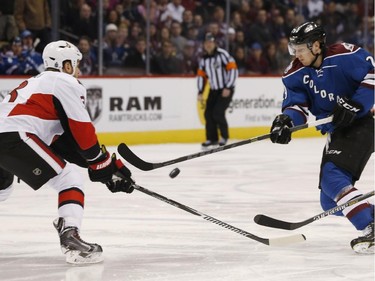 Ottawa Senators defenceman Marc Methot, left, defends as Colorado Avalanche center Nathan MacKinnon swings at the puck as it bounds in the air during the first period.