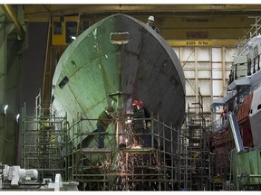 Technicians work on a hull at Halifax Shipyard in Halifax on Thursday, March 7, 2013. Ottawa has signed a $288 million contract for the design of new Arctic offshore patrol ships as part of its shipbuilding procurement project. The Irving-owned shipyard was awarded a large share of a 35-billion-dollar federal procurement project last year.