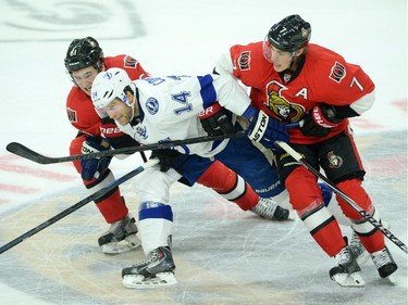 The Ottawa Senators' Mark Stone, left, and Kyle Turris, right, team up to slow down the Tampa Bay Lightning's Brett Connolly during the first period.