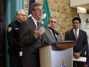 Mayor Jim Watson speaks during a press conference after meeting with Ottawa Police Chief Charles Bordeleau, Ottawa Centre MPP Yasir Naqvi, Coun. Eli El-Chantiry--who chairs the police services board--and Ken Bryden--Acting Staff Sergeant of the Ottawa Police Guns and Gang Unit--on Monday evening, Jan. 12, 2015. The meeting was held to address the spike in gang-related shootings in Ottawa. (David Kawai / Ottawa Citizen)