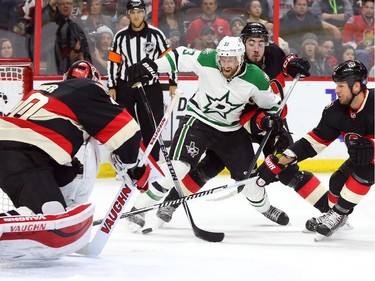 Mika Zibanejad, middle, and Marc Methot, right, of the Ottawa Senators have a hard time controlling Alex Goligoski of the Dallas Stars as goalie Robin Lehner makes the eventual save during second period NHL action.