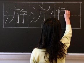 A student writes a Chinese character on the board at Ottawa Capital Chinese School in 2007.