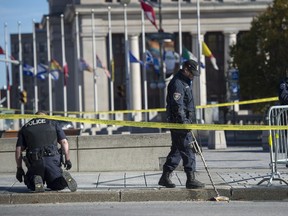Ottawa Police officers comb the area in front of the National War Memorial near Parliament Hill , where Cpl. Nathan Cirillo, 24, was killed by a gunman in Ottawa on Thursday, Oct. 23, 2014. A gunman opened fire at the National War Memorial, then moved to nearby Parliament Hill and wounded a security guard before he was shot, reportedly by Parliament's sergeant-at-arms on Wednesday, Oct. 22, 2014.