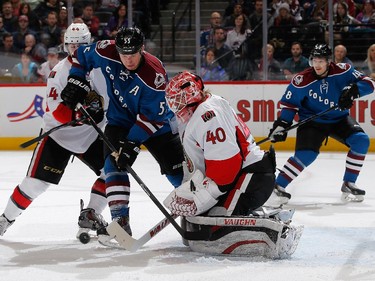 Goalie Robin Lehner #40 of the Ottawa Senators defends the goal as Cody McLeod #55 of the Colorado Avalanche tries to control the puck against Jean-Gabriel Pageau #44 of the Ottawa Senators at Pepsi Center on January 8, 2015 in Denver, Colorado.