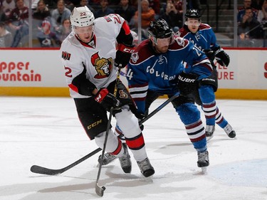 Erik Condra #22 of the Ottawa Senators controls the puck and tries to get off a shot against Marc-Andre Cliche #24 of the Colorado Avalanche.