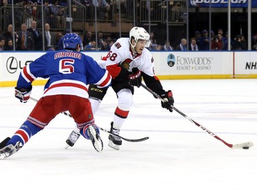 Mike Hoffman #68 of the Ottawa Senators skates with the puck against Dan Girardi #5 of the New York Rangers.