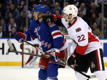 Carl Hagelin #62 of the New York Rangers looks for the puck against Erik Condra #22 of the Ottawa Senators.