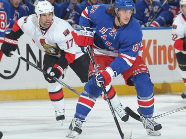 Carl Hagelin #62 of the New York Rangers skates with the puck against David Legwand #17 of the Ottawa Senators.