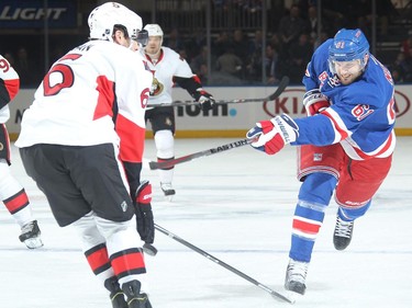 Rick Nash #61 of the New York Rangers shoots the puck against Bobby Ryan #6 of the Ottawa Senators.