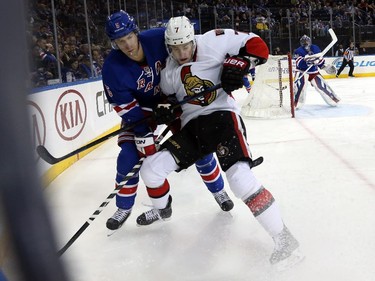 Dan Girardi #5 of the New York Rangers checks Kyle Turris #7 of the Ottawa Senators in the first period.