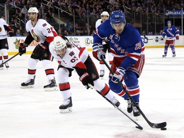 Erik Karlsson #65 of the Ottawa Senators skates for the puck against Ryan Chris Kreider #20 of the New York Rangers.