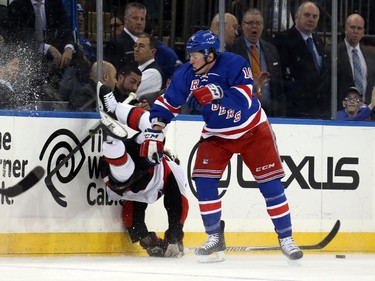 J.T. Miller #10 of the New York Rangers checks Erik Karlsson #65 of the Ottawa Senators in the first period.