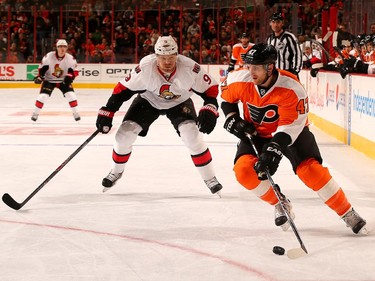 Andrew MacDonald #47 of the Philadelphia Flyers takes the puck as Milan Michalek #9 of the Ottawa Senators defends.