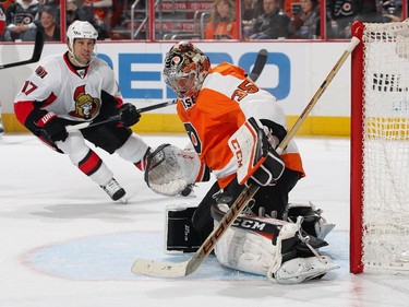 Steve Mason #35 of the Philadelphia Flyers makes a pad save while David Legwand #17 of the Ottawa Senators anticipates a rebound.