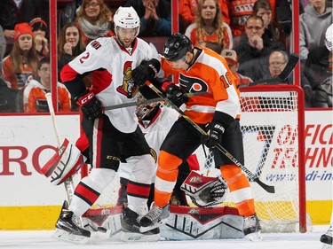 Brayden Schenn #10 of the Philadelphia Flyers attemps a scoring chance in front of goaltender Craig Anderson #41 of the Ottawa Senators while battling with Jared Cowen #2.