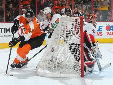 Jakub Voracek #93 of the Philadelphia Flyers wraps around the net as Erik Karlsson #65 and Craig Anderson #41 of the Ottawa Senators defend.