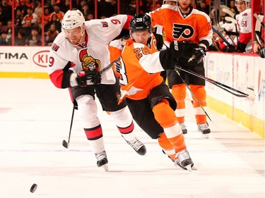 Milan Michalek #9 of the Ottawa Senators and Claude Giroux #28 of the Philadelphia Flyers fight for the puck in the first period.