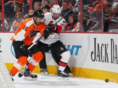 Sean Couturier #14 of the Philadelphia Flyers battles in the corner for the loose puck with Clarke MacArthur #16 of the Ottawa Senators.
