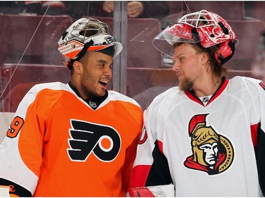 Ray Emery #29 of the Philadelphia Flyers shares a laugh with Robin Leher #40 of the Ottawa Senators during warmups.