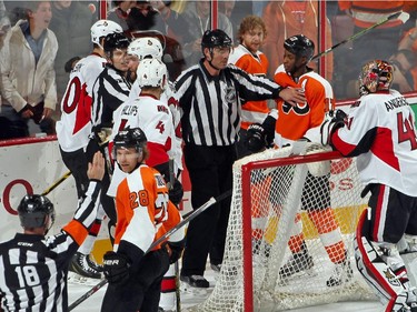 Linesmen Tim Nowak #77 and Derek Amell #75 break up a scrum after a penalty called on Jakub Voracek #93 of the Philadelphia Flyers for roughing Eric Gryba #62 of the Ottawa Senators.