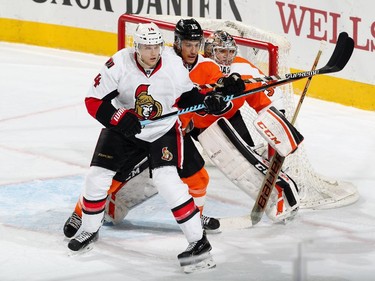 Michael Del Zotto #15 of the Philadelphia Flyers battles in front of Steve Mason #35 with Colin Greening #14 of the Ottawa Senators.