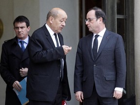 French Defence Minister Jean-Yves Le Drian talks with French President Francois Hollande next to French Prime minister, Manuel Valls as they leave a crisis meeting on 10 January 2015 at the Elysee presidential palace on 10 January 2015 in Paris, France.