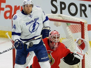 Ottawa Senators' Robin Lehner keeps his eye on the puck as Tampa Bay Lightning's Brett Connolly jumps to avoid a shot during first period NHL hockey action in Ottawa on Sunday, Jan 4, 2015.