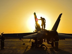 Royal Canadian Air Force ground crew perform post flight checks on a CF-18 fighter jet in Kuwait after a sortie over Iraq during Operation IMPACT on November 3, 2014.