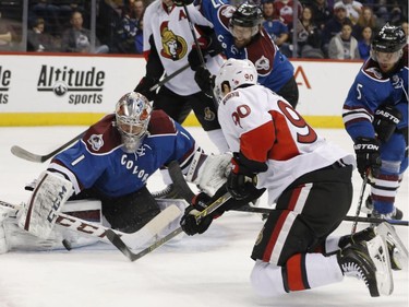 Ottawa Senators right wing Alex Chiasson, front, has his redirected shot stopped by Colorado Avalanche goalie Semyon Varlamov, of Russia, as defensemen Brad Stuart, back center, and Nate Guenin help Varlamov during the second period of an NHL hockey game Thursday, Jan. 8, 2015, in Denver.