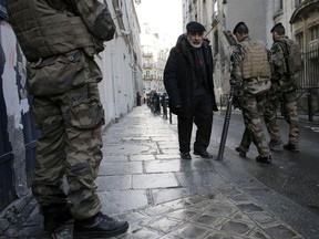 Soldiers patrol a street in Paris, Wednesday, Jan. 14, 2015. France ordered 10,000 troops into the streets Monday to protect sensitive sites -- nearly half of them to guard Jewish schools -- as it hunted for accomplices to the Islamic militants who left 17 people dead as they terrorized the nation.