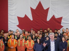 Flanked by British Columbia Institute of Technology heavy duty mechanical trade students, Prime Minister Stephen Harper speaks during an announcement about the apprentice loan program at the BCIT Annacis Island Campus in Delta, B.C., on Thursday January 8, 2015.