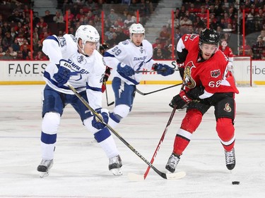 Mike Hoffman #68 of the Ottawa Senators skates for the puck against Matt Carle #25 of the Tampa Bay Lightning at Canadian Tire Centre on January 4, 2015 in Ottawa, Ontario, Canada.