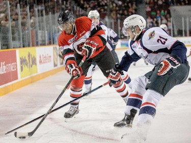 Taylor Davis, left, and Logan Brown battle for the puck in the first period.