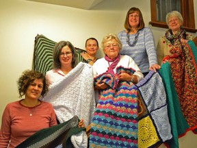 The Warm Hands Network's Anita Barewal, from left, Amy Bell, Carlene Paquette, Jeannine Turcotte, Claire Gorman and Suzanne Atkinson hold up blankets to be shipped to children in need.
