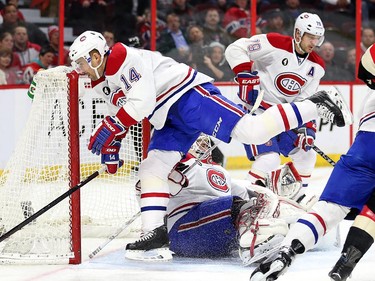 Tomas Plekanec jumps over a sprawling Dustin Tokarski in the first period.