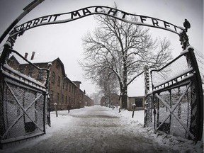 A woman walks through snow near the entrance to the former Nazi concentration camp Auschwitz-Birkenau with the lettering 'Arbeit macht frei' (Work makes you free) in Oswiecim, Poland, on Jan. 25, 2015, days before the 70th anniversary of the liberation of the camp by Russian forces.