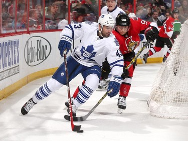 Nazem Kadri #43 of the Toronto Maple Leafs skates the puck behind the net as Alex Chiasson #90 of the Ottawa Senators pressures on the forecheck.