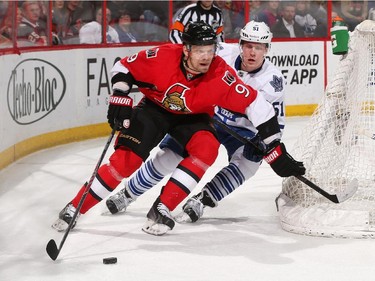 Milan Michalek #9 of the Ottawa Senators stickhandles the puck behind the net against Jake Gardiner #51 of the Toronto Maple Leafs.