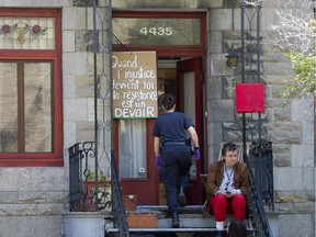 A police officer enters the home of Quebec MNA Amir Khadir following an early morning raid that resulted in the arrest of his daughter Yalda Machouf-Khadir in 2012 in Montreal.