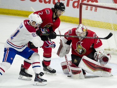 Ottawa Senators defenseman Jared Cowen ties up Montreal Canadiens center Lars Eller as goalie Andrew Hammond makes a save during first period NHL action.