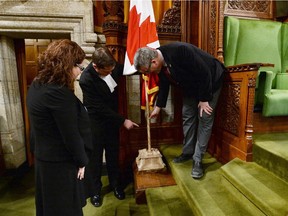 House of Commons Speaker Andrew Scheer, MP Craig Scott and the Curator of the House of Commons, Johanna Mizgala look at a new flagpole and stand in the House of Commons on Parliament Hill in Ottawa on Wednesday, February 18, 2015. The flag pole is fashioned from wood from the famed silver maple tree that inspired Alexander Muir's song "The Maple Leaf Forever," composed in 1867.
