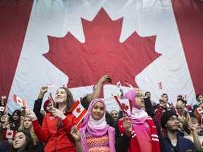Audience members wave Canadian flag as they wait for the arrival of Liberal Leader Justin Trudeau and former prime minister Jean Chretien at an event to celebrate the 50th Anniversary of the Canadian Flag, in Mississauga Ont., on Sunday February 15 2015.