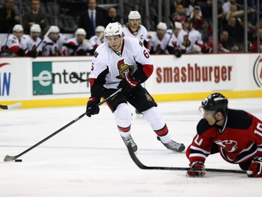 New Jersey Devils defenseman Peter Harrold (10) falls to the ice as Ottawa Senators right wing Bobby Ryan (6) skates with the puck during the first period.