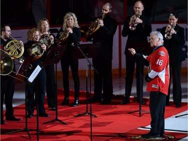 by Pinchas Zukerman leads the 11-member brass choir of the National Arts Centre Orchestra in playing the national anthem.